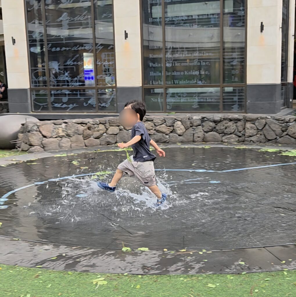 インターナショナルマーケットプレイスで水遊びする2歳児