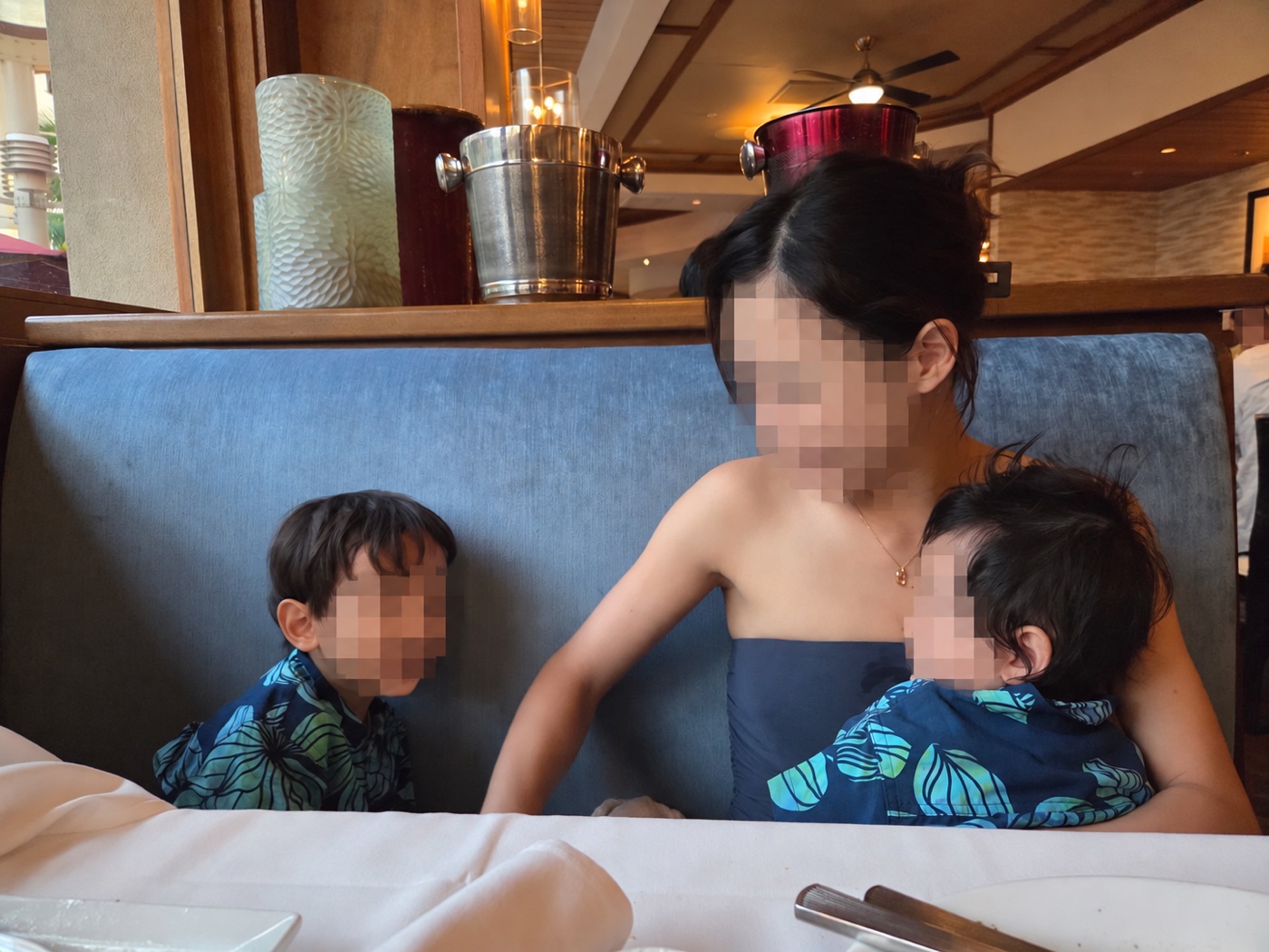 ルースズ・クリスのソファ席で、お揃いのアロハシャツを着た2人の子どもと母親（顔はぼかし加工）